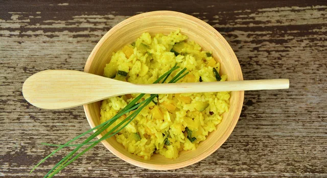 Arroz amarelo com pequi em tigela de madeira