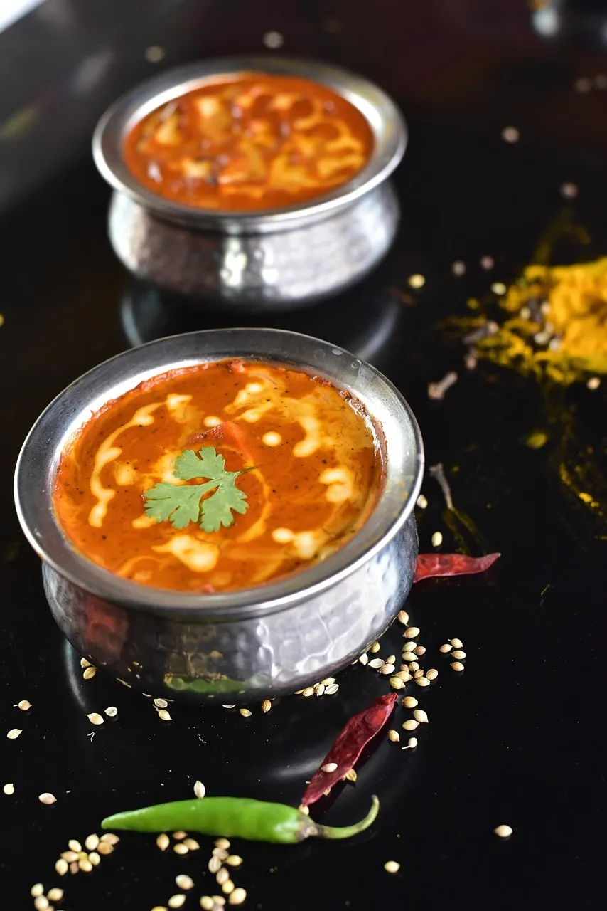 Butter chicken servido em tigelas de metal