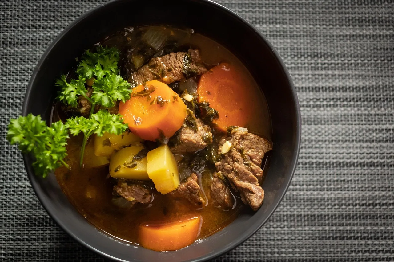 Coq au vin com legumes em panela escura